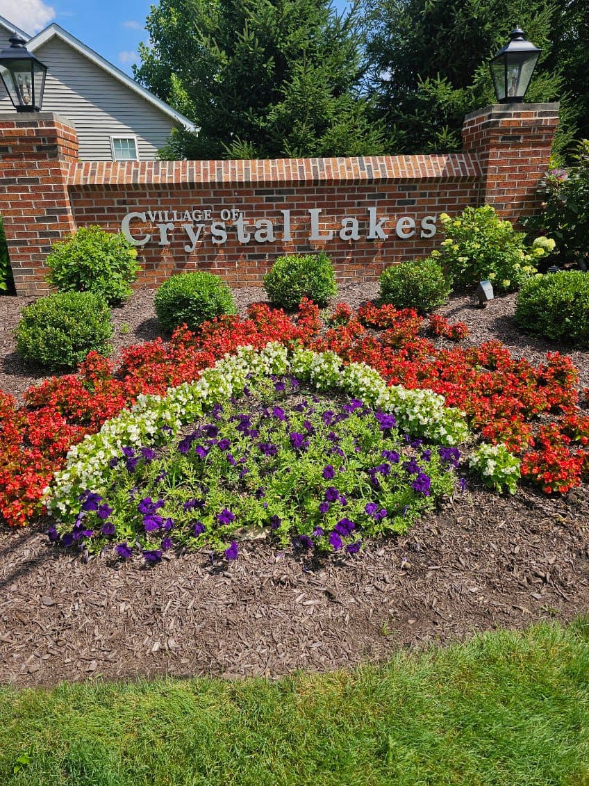 Vibrant annual flower bed planting at a brick entrance sign